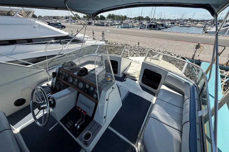 Slide: The Image of 1989 Carver 340 Santego boat interior with helm, seating, and marina view. - 10