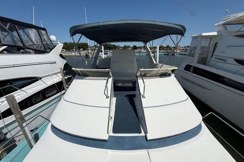 Slide: The Image of 1989 Carver 340 Santego yacht docked at marina, featuring spacious deck and canopy. - 14