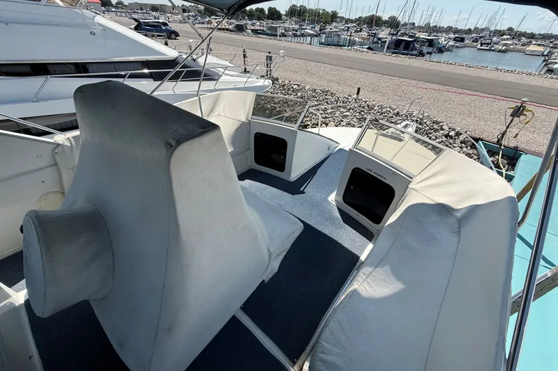Slide: The Image of 1989 Carver 340 Santego boat interior with seating, docked at a marina. - 7