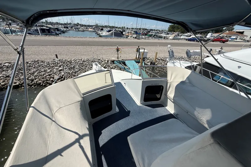 Slide: The Image of 1989 Carver 340 Santego yacht interior with marina view, featuring spacious seating and canopy. - 8