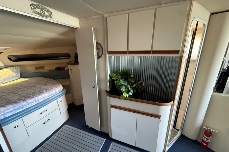 Slide: The Image of 1989 Carver 340 Santego cabin interior with bed, cabinets, and decorative plant. - 26