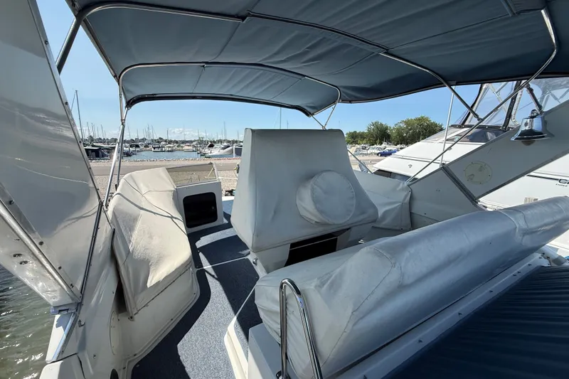 Slide: The Image of 1989 Carver 340 Santego boat interior with covered seating and marina view. - 6
