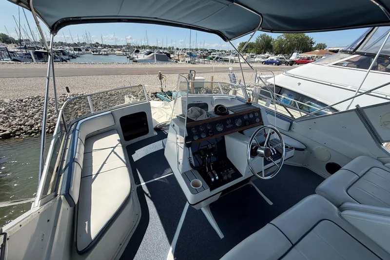 Slide: The Image of 1989 Carver 340 Santego boat interior with helm, seating, and marina view. - 9