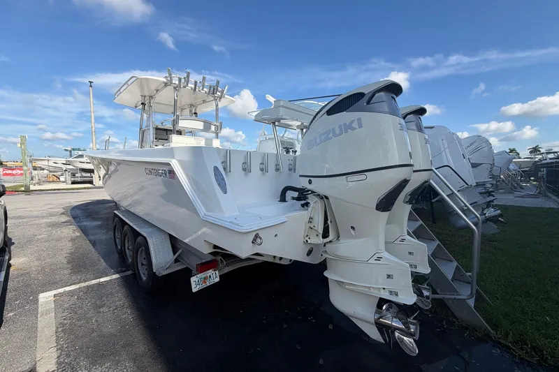 Slide: The Image of 2007 Contender 33 Tournament boat with dual Suzuki outboard engines, parked on a trailer. - 2