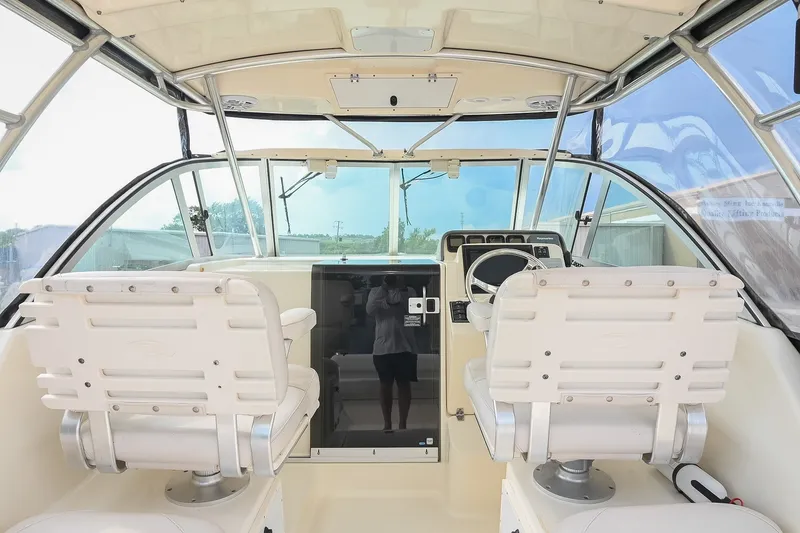 Slide: The Image of 2007 Pursuit OS 285 Offshore boat cockpit with dual white captain chairs and steering console. - 21