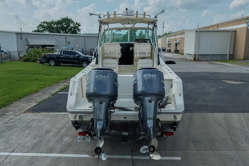 Slide: The Image of 2007 Pursuit OS 285 Offshore boat with dual 250 horsepower engines, parked outdoors. - 3