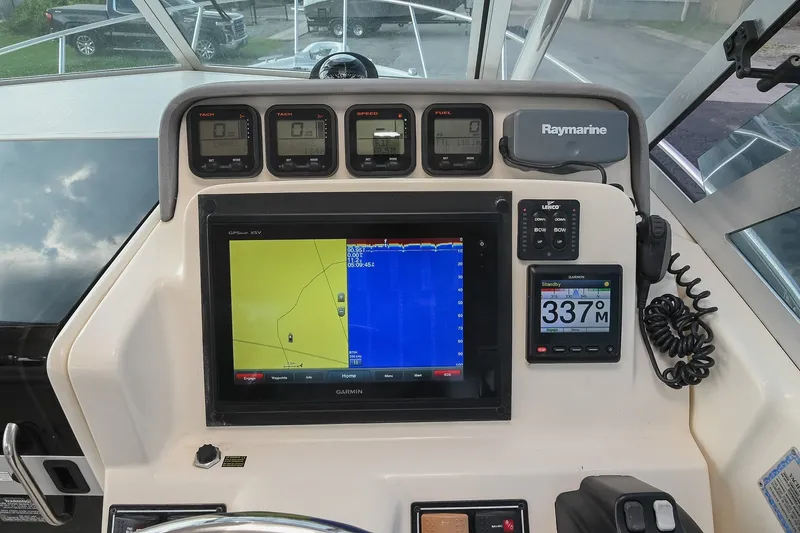 Slide: The Image of Dashboard of a 2007 Pursuit OS 285 Offshore boat with navigation and control instruments. - 27