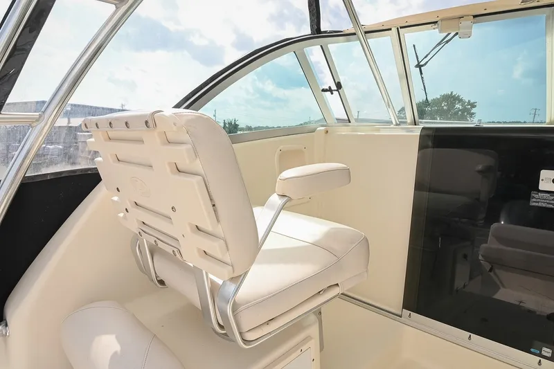 Slide: The Image of 2007 Pursuit OS 285 Offshore boat interior with white captain's chair and windshield. - 22