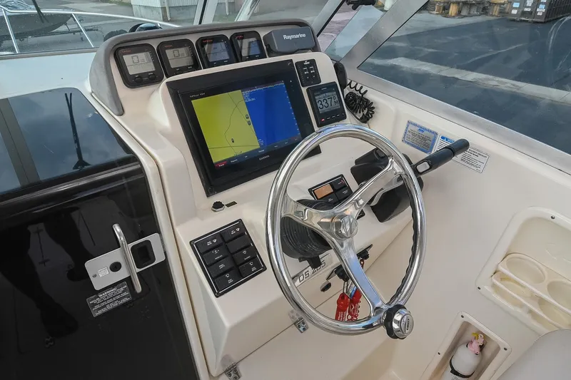 Slide: The Image of 2007 Pursuit OS 285 Offshore boat dashboard with navigation system and steering wheel. - 26