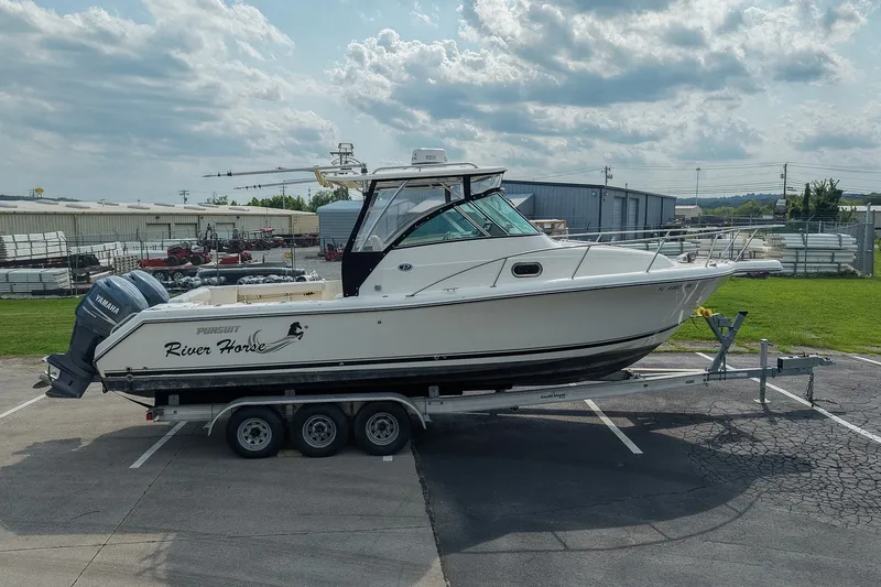 Slide: The Image of 2007 Pursuit OS 285 Offshore boat on trailer, parked outdoors under cloudy sky. - 5