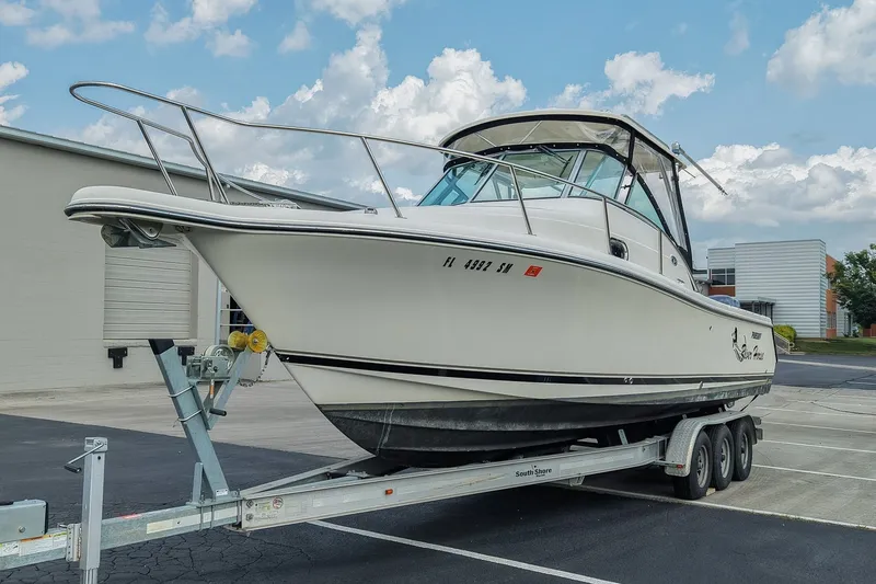 Slide: The Image of 2007 Pursuit OS 285 Offshore boat on trailer, parked outdoors under a cloudy sky. - 7