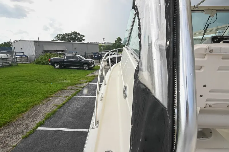 Slide: The Image of 2007 Pursuit OS 285 Offshore boat parked near a grassy area and a black truck. - 36