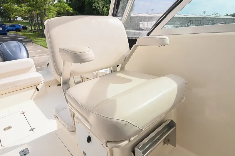 Slide: The Image of Captain's chair on 2007 Pursuit OS 285 Offshore boat, featuring comfortable seating and armrests. - 23