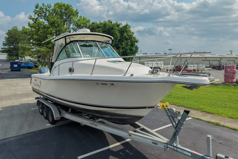 Slide: The Image of 2007 Pursuit OS 285 Offshore boat on trailer, parked outdoors under a cloudy sky. - 6