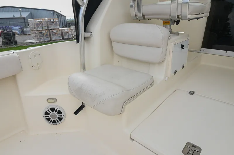 Slide: The Image of 2007 Pursuit OS 285 Offshore boat interior with white seating and storage compartment. - 17
