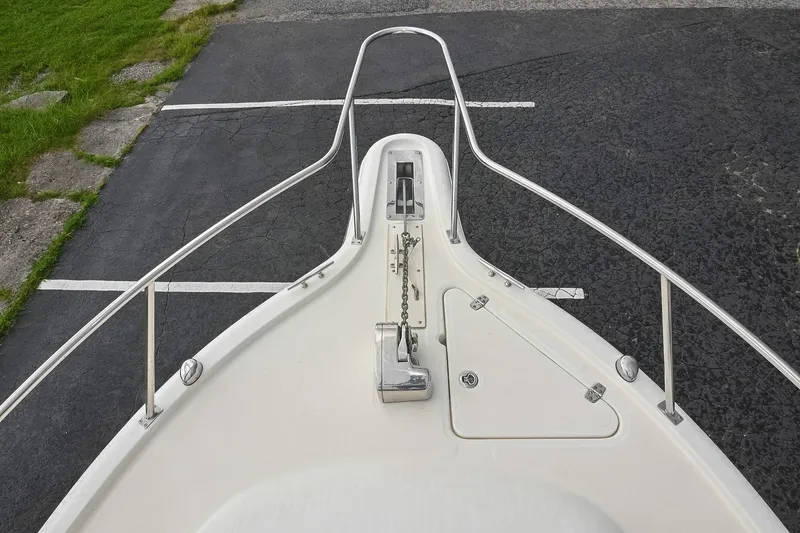Slide: The Image of 2007 Pursuit OS 285 Offshore boat bow with anchor and railing, parked on asphalt. - 38