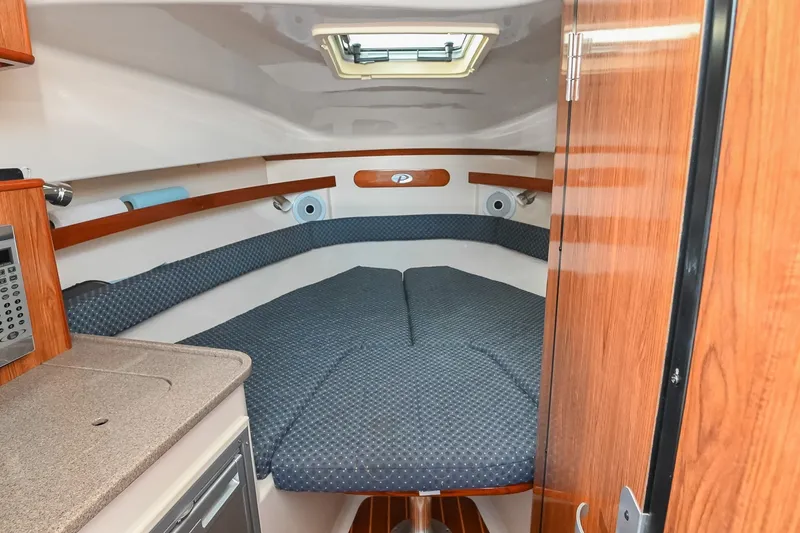 Slide: The Image of Cozy cabin interior of 2007 Pursuit OS 285 Offshore boat with cushioned seating. - 30