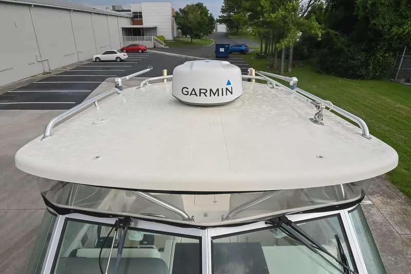 Slide: The Image of 2007 Pursuit OS 285 Offshore boat with Garmin radar, parked near a building. - 40