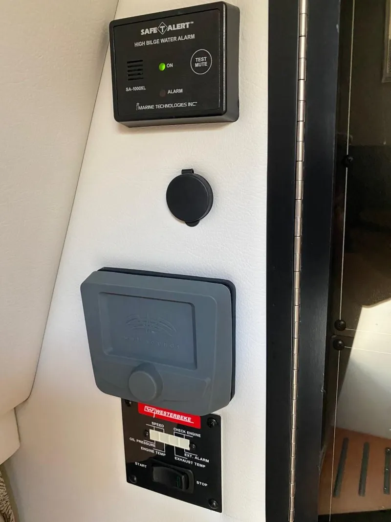 Slide: The Image of A control panel with a Safe-T-Alert water alarm and a Crownline switch in a boat. - 24