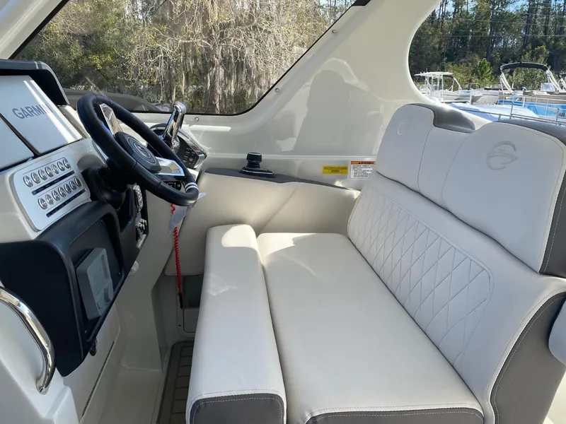 Slide: The Image of The image shows the cockpit of a 2023 Crownline 310 CRX with comfortable seating and a modern helm. - 14