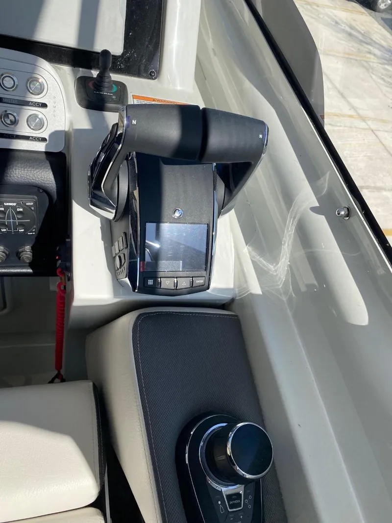 Slide: The Image of Close-up of the helm of a 2023 Crownline 310 CRX with modern controls. - 16