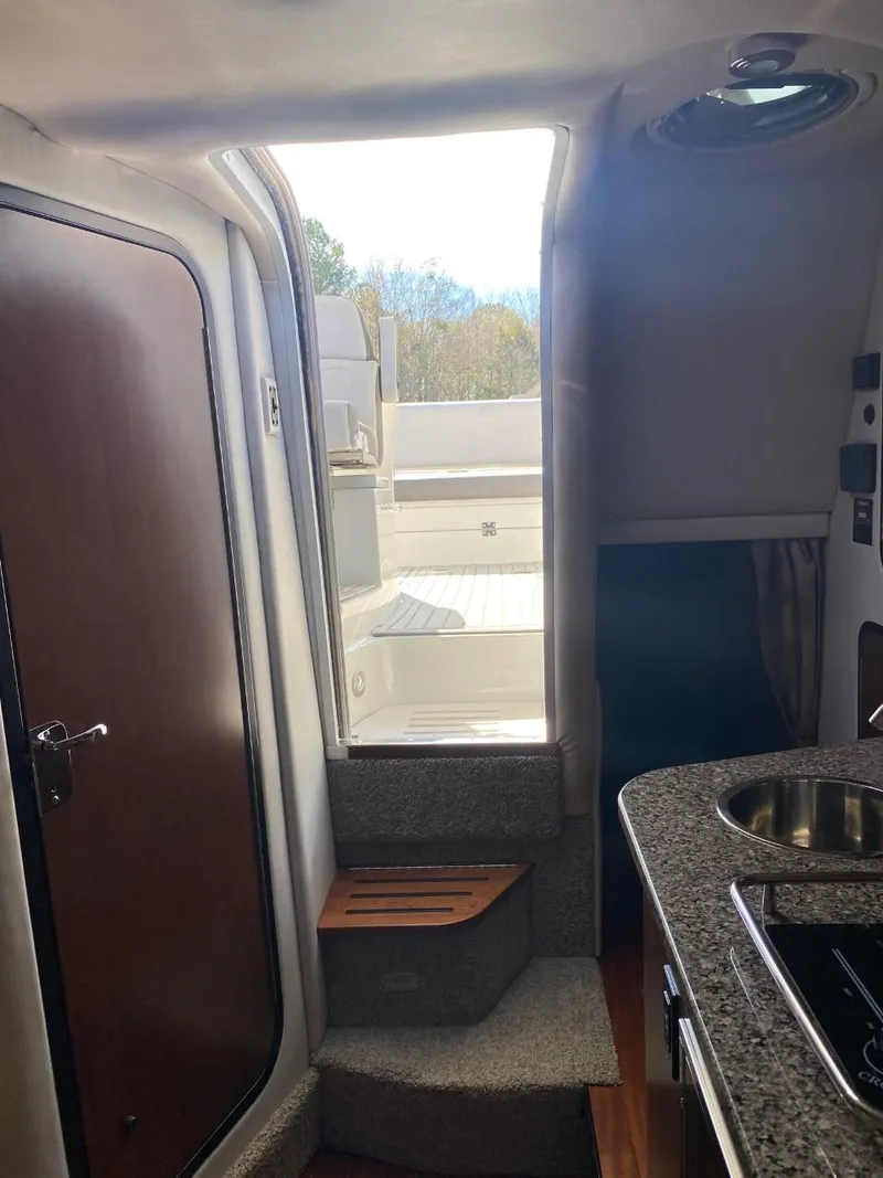 Slide: The Image of Interior of a 2023 Crownline 310 CRX with stairs and a kitchenette area. - 28