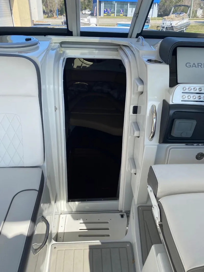 Slide: The Image of The cabin of a 2023 Crownline 310 CRX with white upholstery and a Garmin display. - 13