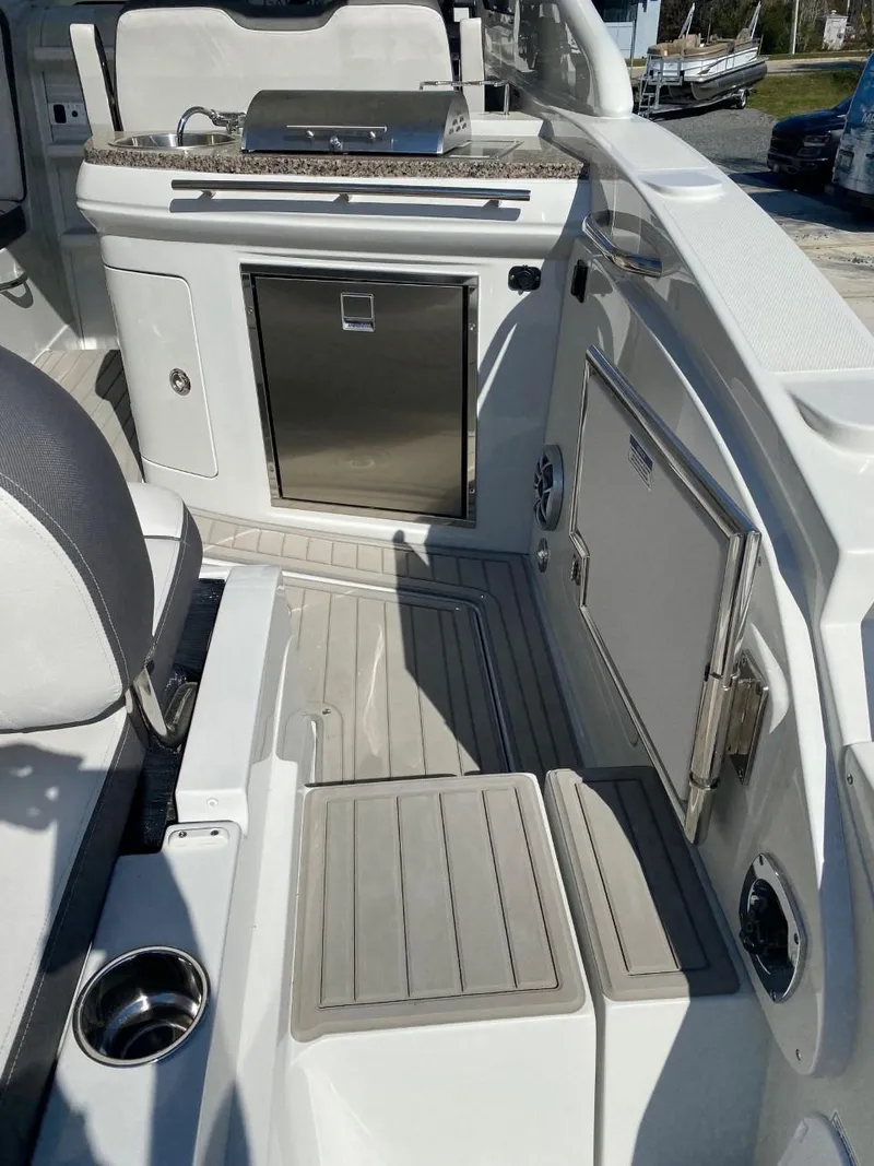 Slide: The Image of The image shows the cockpit of a 2023 Crownline 310 CRX with a small kitchenette. - 8