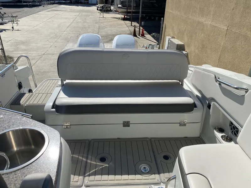 Slide: The Image of The image shows the stern of a 2023 Crownline 310 CRX with a cushioned bench and a sink. - 9