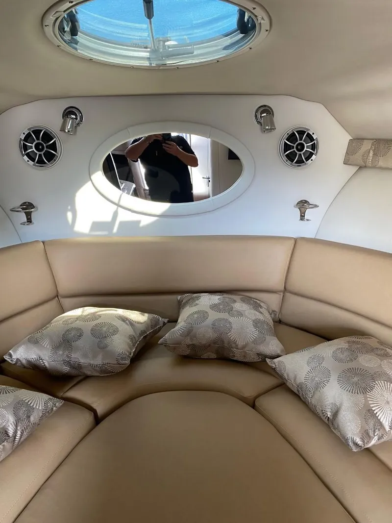 Slide: The Image of The image shows the interior of a 2023 Crownline 310 CRX with beige upholstery and decorative pillows. - 27