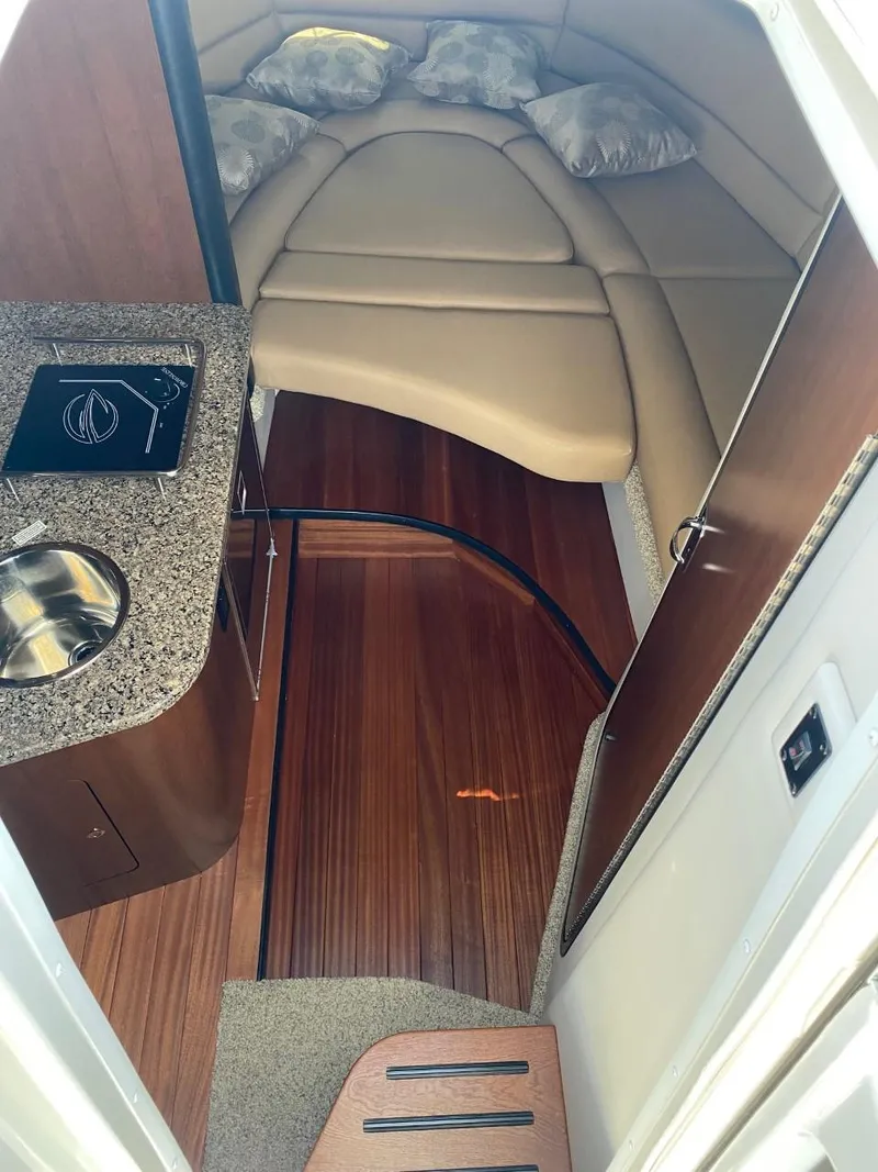 Slide: The Image of Interior of a 2023 Crownline 310 CRX featuring a sleek cabin and kitchenette. - 20