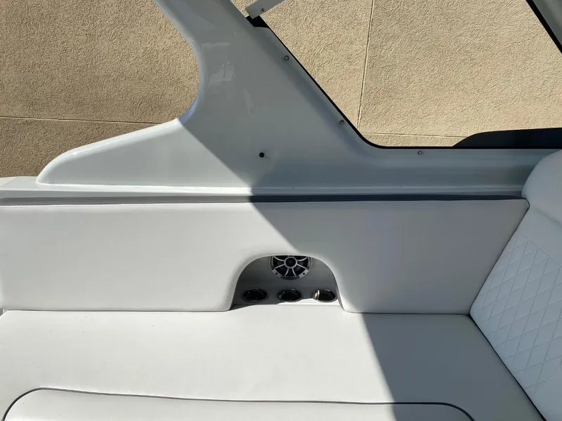 Slide: The Image of The 2023 Crownline 310 CRX features sleek white interior seating with a built-in speaker. - 10