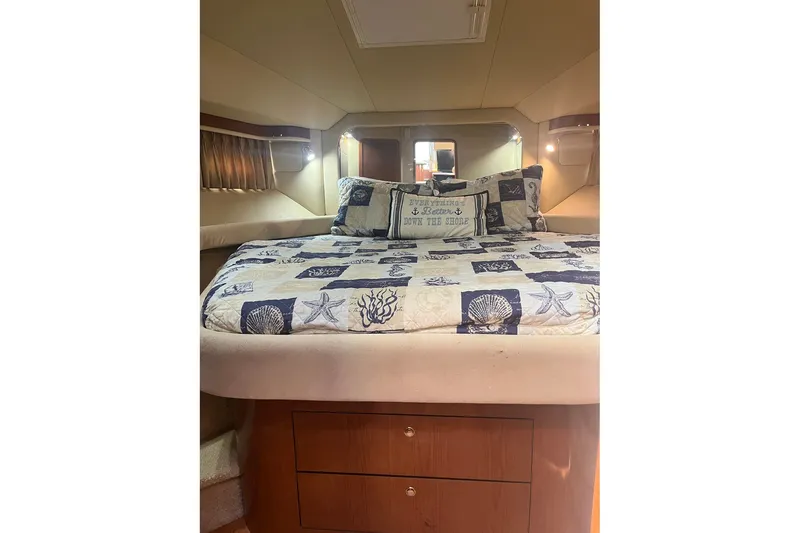 Slide: The Image of Cozy bedroom interior of 2002 Sea Ray 480 Motor Yacht with nautical-themed bedding. - 24