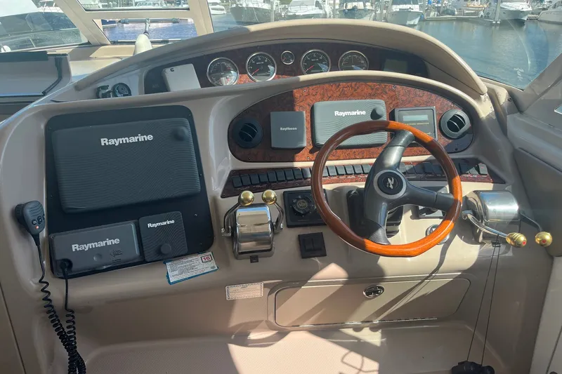 Slide: The Image of Helm of 2002 Sea Ray 480 Motor Yacht with Raymarine navigation equipment and wooden steering wheel. - 19