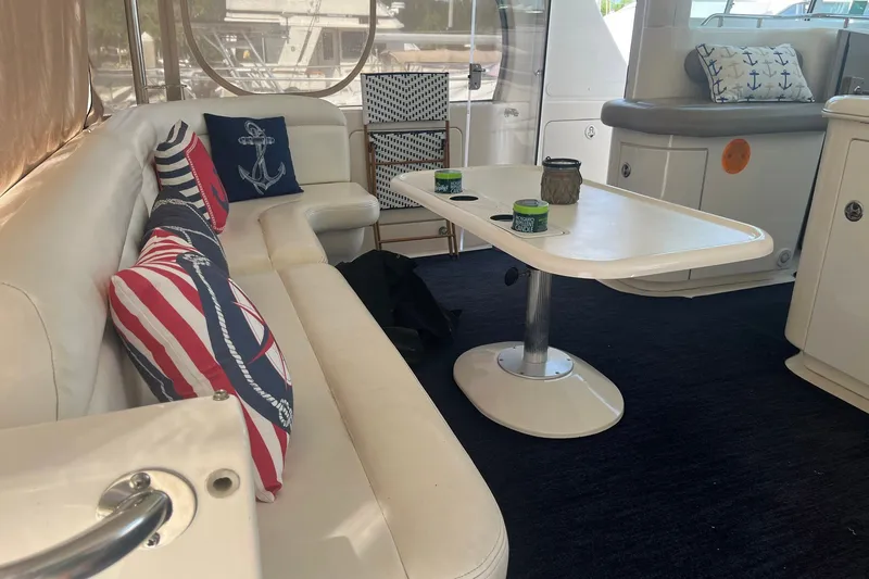 Slide: The Image of Interior of 2002 Sea Ray 480 Motor Yacht with nautical-themed cushions and table. - 2