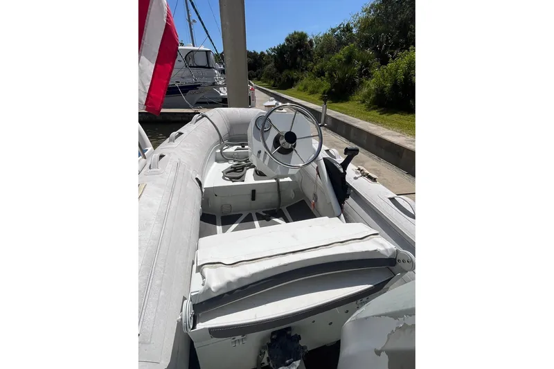 Slide: The Image of 2002 Sea Ray 480 Motor Yacht with inflatable tender and steering wheel, docked near greenery. - 10