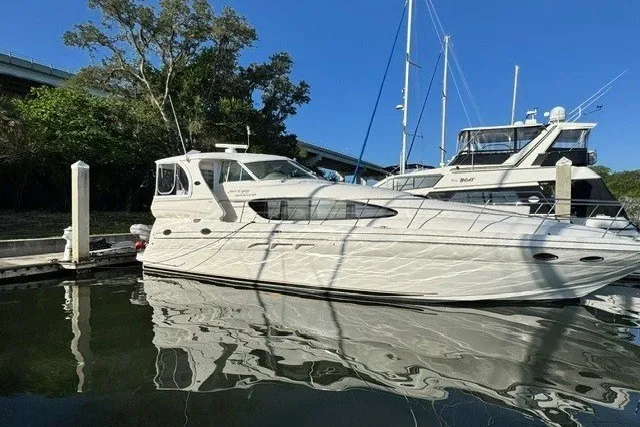 Slide: The Image of 2002 Sea Ray 480 Motor Yacht docked in a serene marina setting. - 0