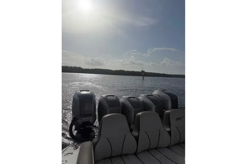 Slide: The Image of 2019 Midnight Express 43 Open boat with multiple engines on a sunny day at sea. - 16