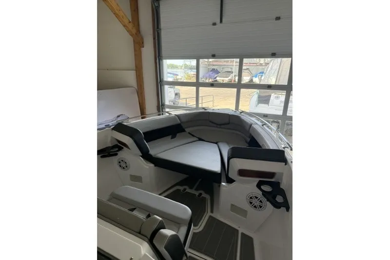Slide: The Image of 2027 Monterey Elite 27 SD boat interior with cushioned seating in a garage setting. - 17