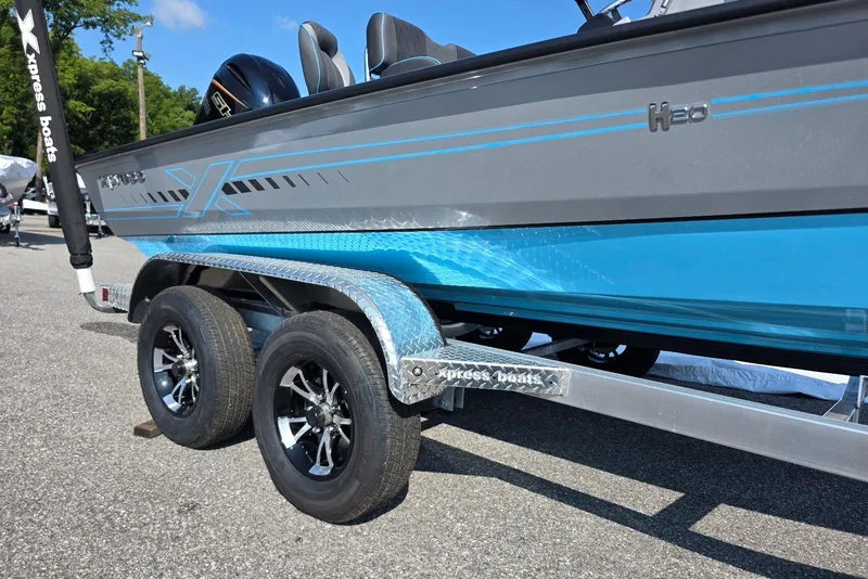 Slide: The Image of 2027 Xpress H20B Bay boat on trailer, featuring sleek design and dual axles. - 2