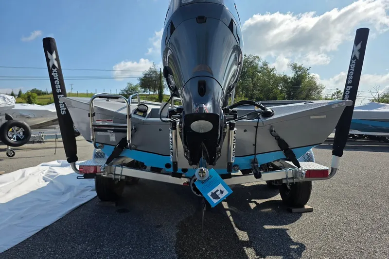 Slide: The Image of 2027 Xpress H20B Bay boat rear view with motor and trailer in outdoor setting. - 4