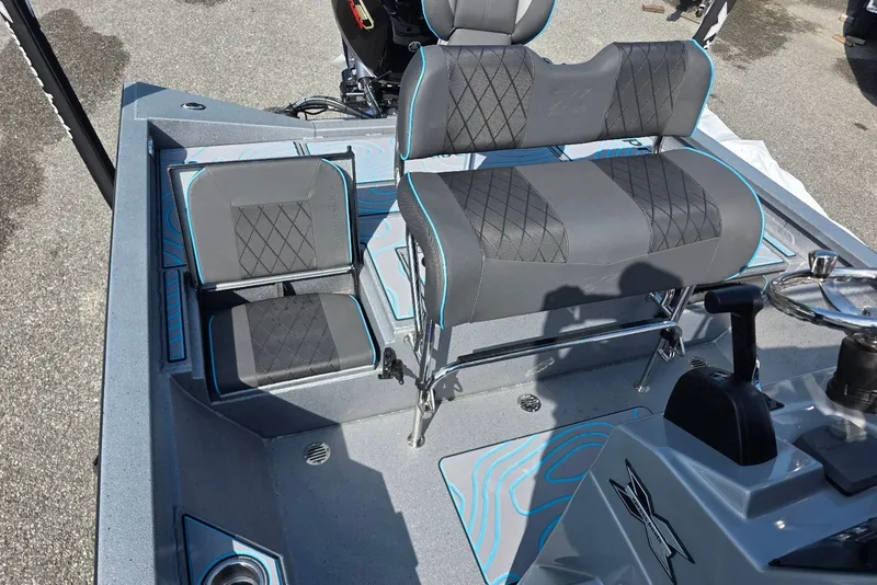 Slide: The Image of 2027 Xpress H20B Bay boat interior with gray and blue seating and steering console. - 15
