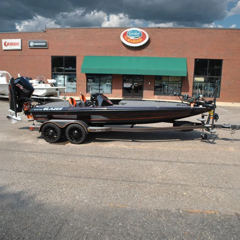 The Image of A 2021 Blazer 650 Pro Tour boat on a trailer in front of a brick building. - 0