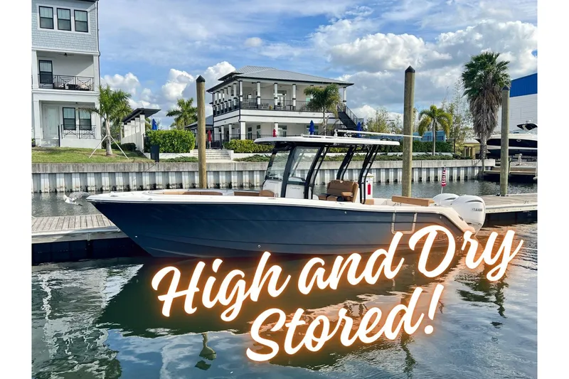 Slide: The Image of 2025 Robalo R302 Center Console boat docked, labeled "High and Dry Stored." - 1