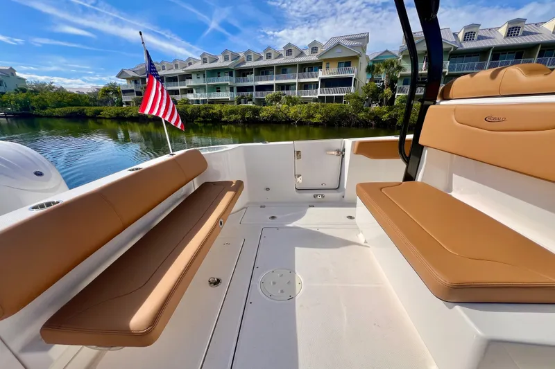 Slide: The Image of 2025 Robalo R302 Center Console boat interior with tan seating and American flag. - 11