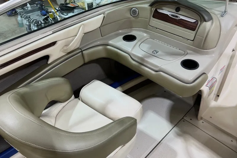 Slide: The Image of Interior of a 2004 Sea Ray 200 Select boat, featuring beige seating and cup holders. - 14