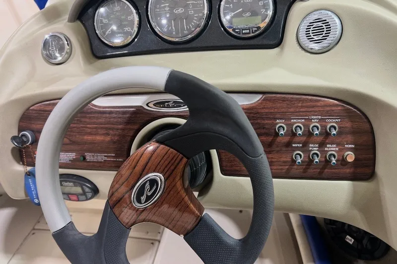 Slide: The Image of Steering wheel and dashboard of 2004 Sea Ray 200 Select boat with wood accents. - 12
