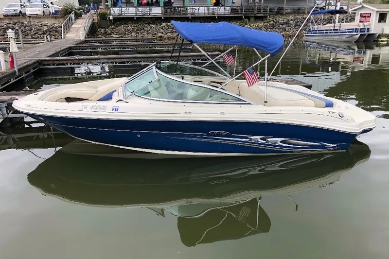 The Image of 2004 Sea Ray 200 Select boat docked with blue canopy and American flags. - 0