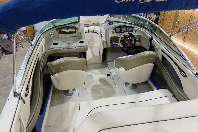 Slide: The Image of 2004 Sea Ray 200 Select boat interior with beige seating and blue canopy. - 6
