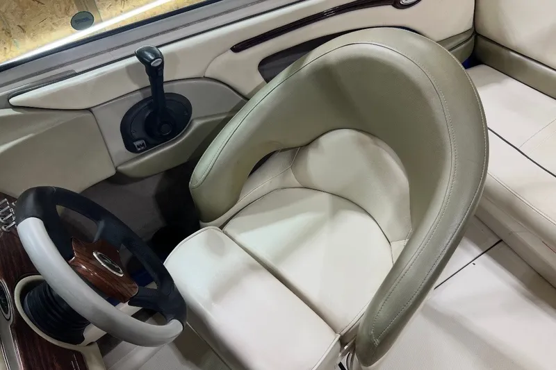Slide: The Image of Interior of a 2004 Sea Ray 200 Select boat, featuring a sleek steering wheel and comfortable seating. - 9